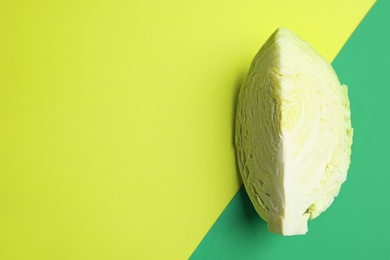 Cut ripe cabbage on color background, top view