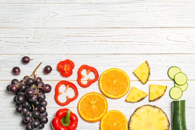 Rainbow composition with fresh vegetables and fruits on wooden background, flat lay