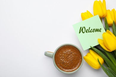 Image of Welcome card, beautiful yellow tulips and cup of aromatic coffee on white background, flat lay