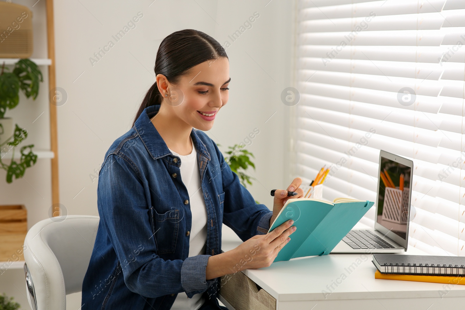 Photo of Woman studying on laptop at home. Online translation course