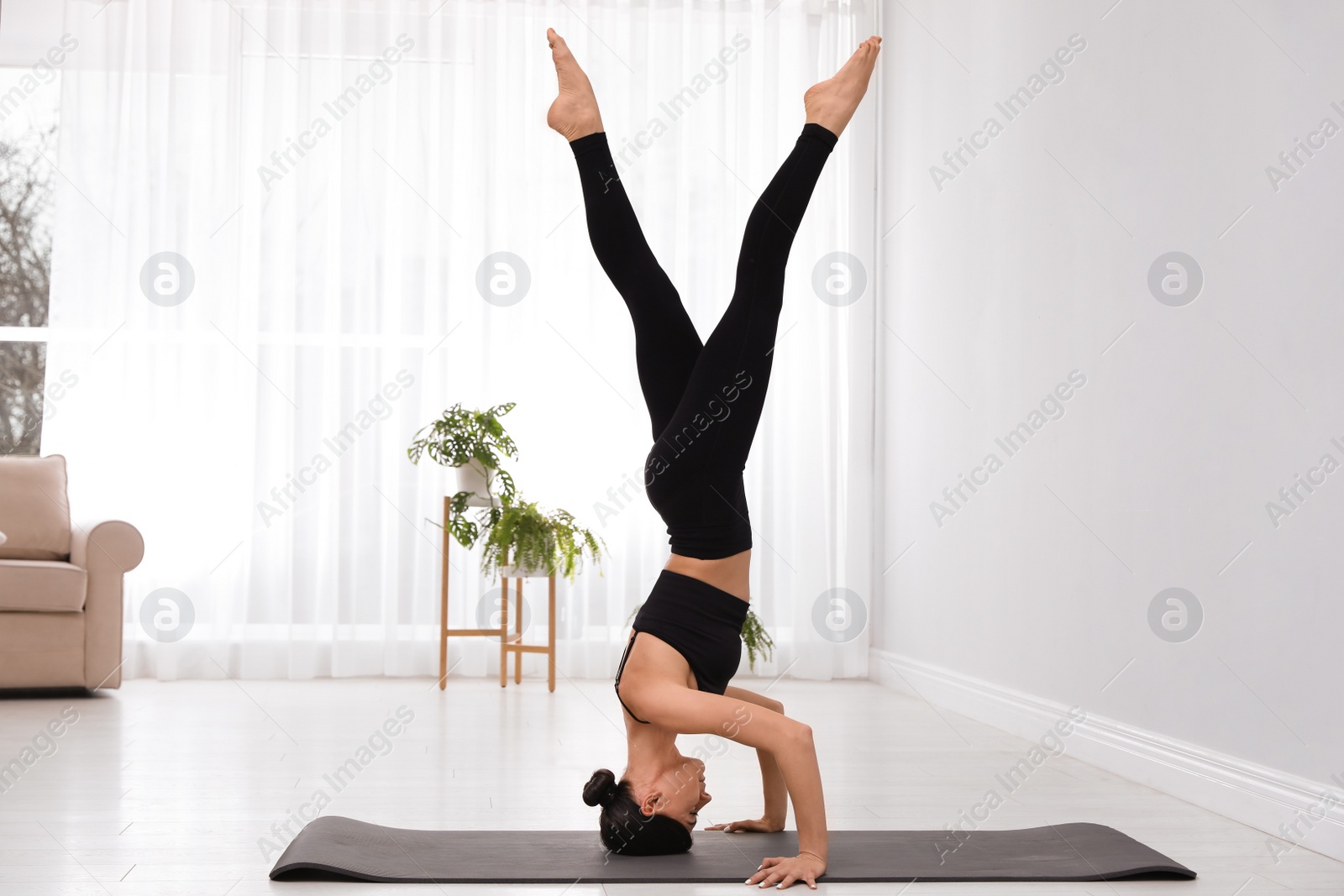 Photo of Professional young acrobat practicing yoga at home