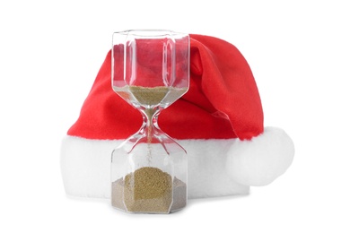 Photo of Hourglass and Santa hat on white background. Christmas countdown