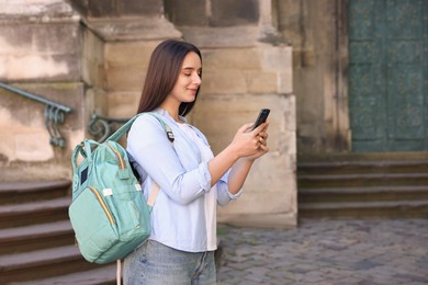 Photo of Travel blogger using smartphone on city street