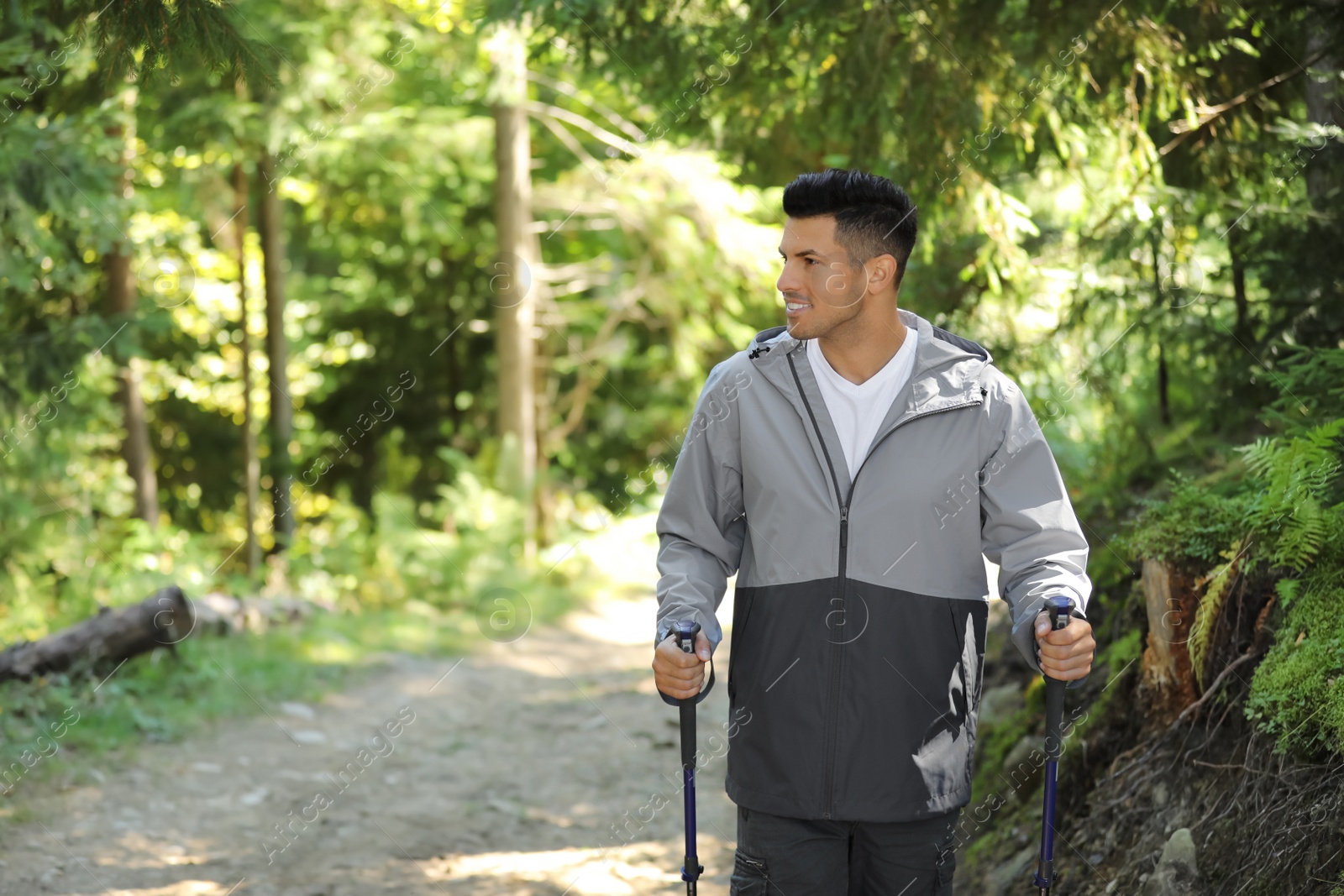 Photo of Man with trekking poles hiking in forest