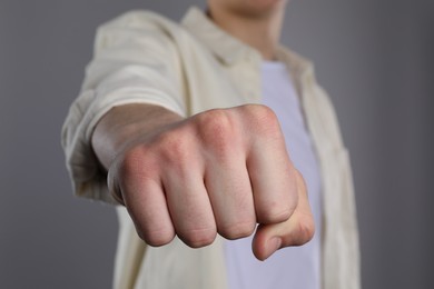 Man showing fist with space for tattoo on grey background, selective focus