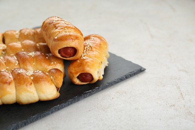 Photo of Delicious sausage rolls on beige table, closeup. Space for text