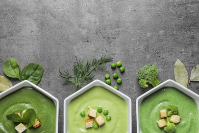 Photo of Flat lay composition with different fresh vegetable detox soups made of green peas, broccoli and spinach in dishes on table. Space for text