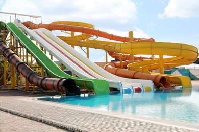 Photo of Beautiful view of water park with colorful slides and swimming pool on sunny day