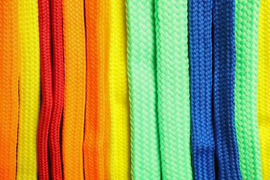 Photo of Colorful shoelaces as background, closeup. Stylish accessory