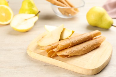 Delicious fruit leather rolls and pears on white wooden table. Space for text