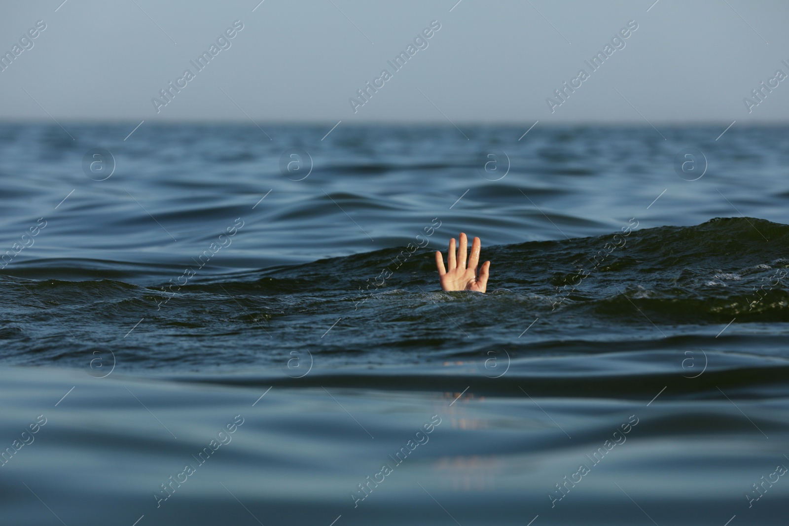 Photo of Drowning woman reaching for help in sea