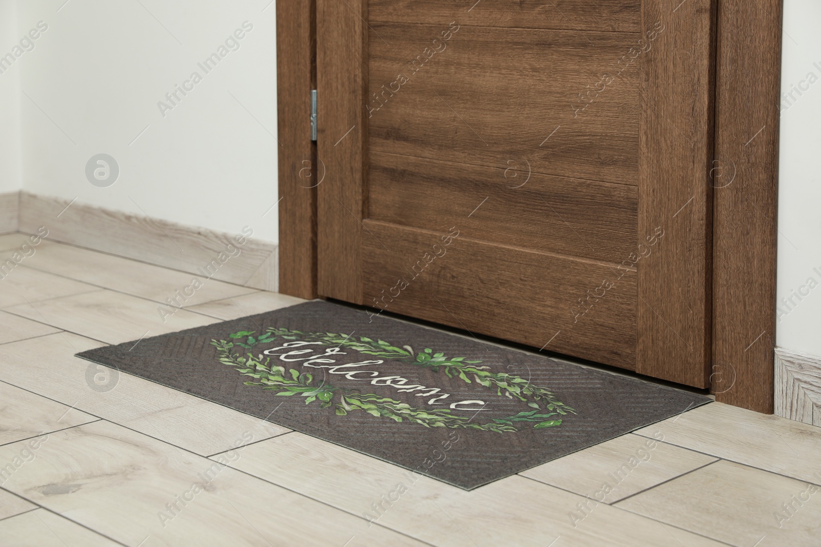 Photo of Beautiful doormat with word Welcome on floor near entrance