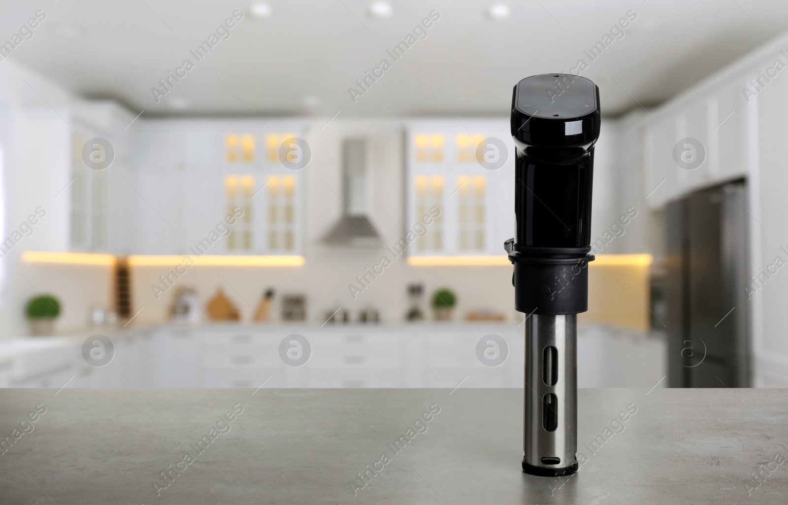 Image of Sous vide cooker on light grey table in kitchen, space for text. Thermal immersion circulator