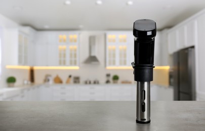 Image of Sous vide cooker on light grey table in kitchen, space for text. Thermal immersion circulator