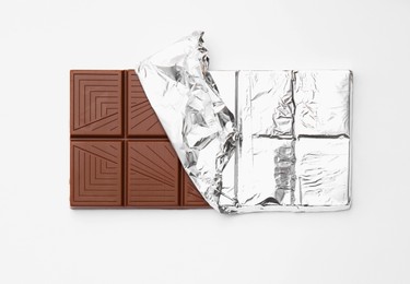 Photo of Tasty chocolate bar on white background, top view