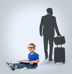 Little boy with book dreaming to be businessman. Silhouette of man behind kid's back