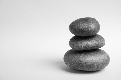 Photo of Stacked zen stones on white background. Space for text