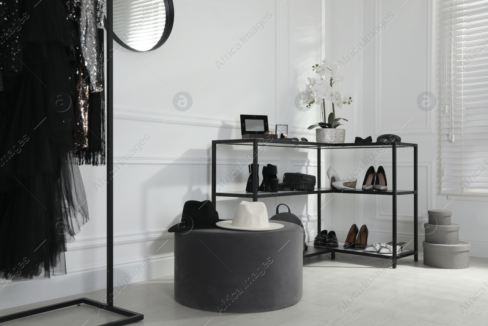 Photo of Shelving unit with stylish women's shoes, clothes and accessories in dressing room