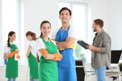 Team of professional janitors in uniform indoors