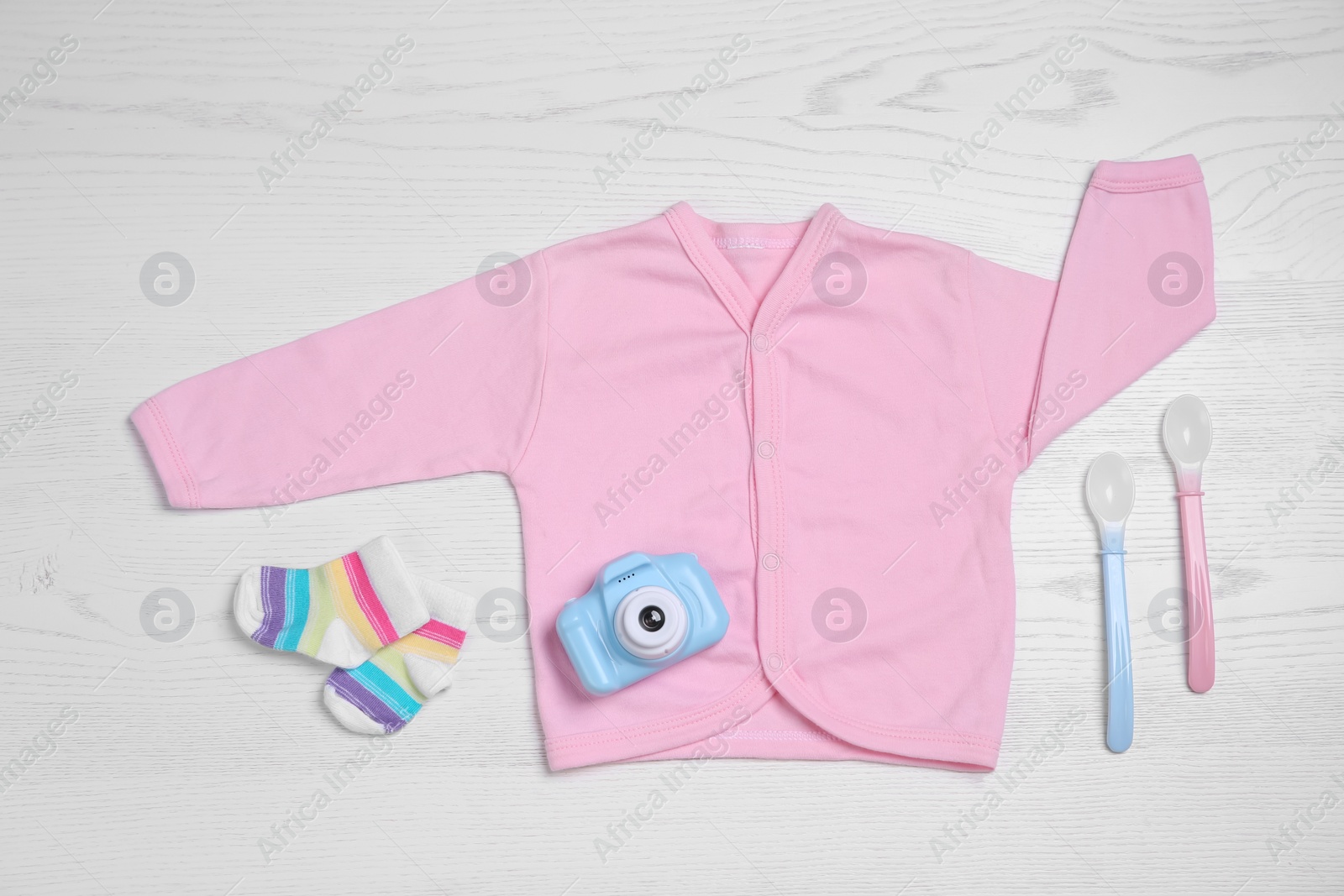 Photo of Flat lay composition with baby clothes and accessories on white wooden table