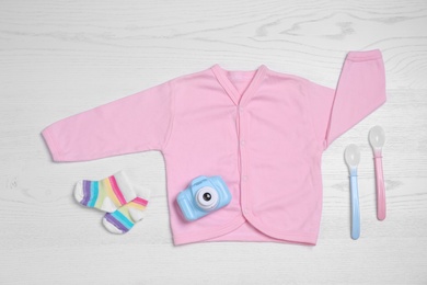 Flat lay composition with baby clothes and accessories on white wooden table