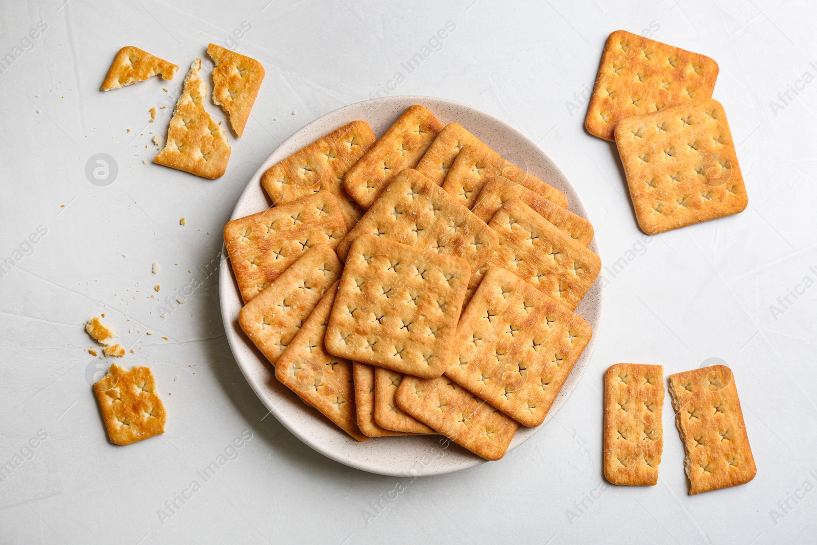 Photo of Delicious crispy crackers on light table, flat lay