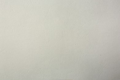 Texture of light grey paper sheet as background, closeup