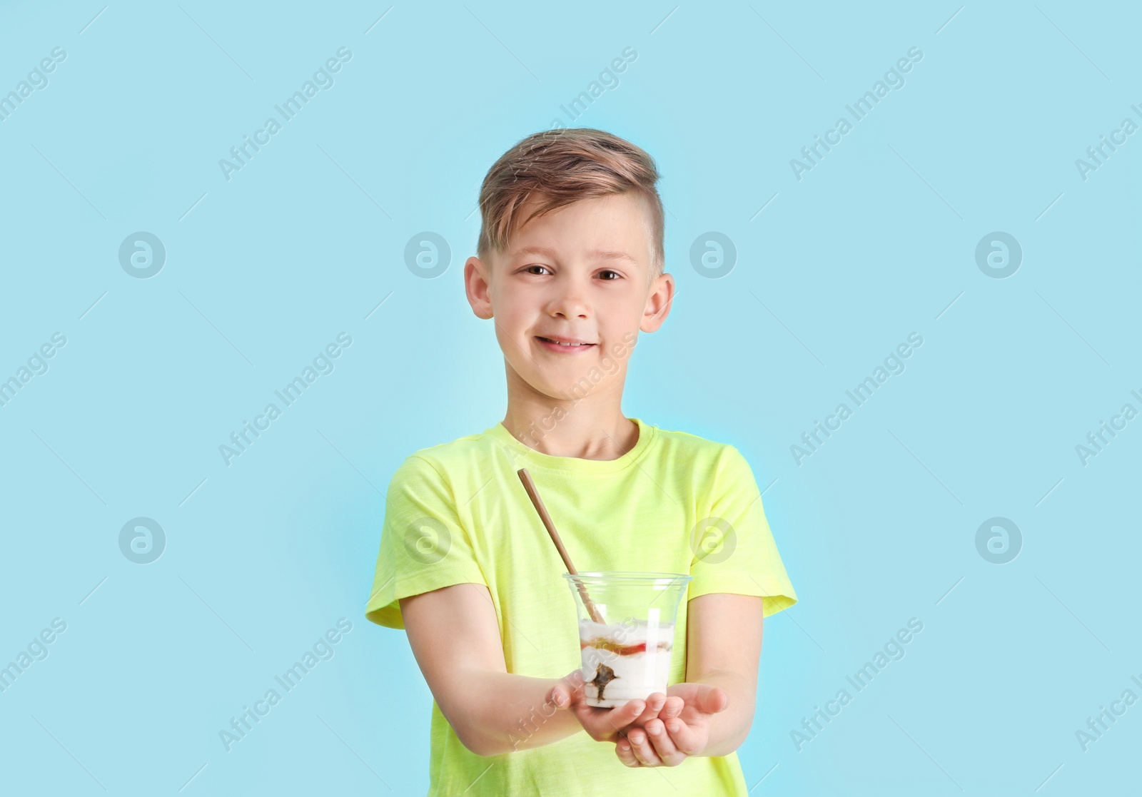 Photo of Little boy with yogurt on color background