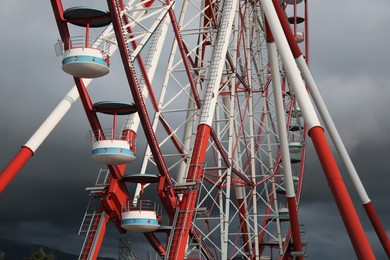 Photo of Beautiful large Ferris wheel against heavy rainy clouds outdoors, closeup