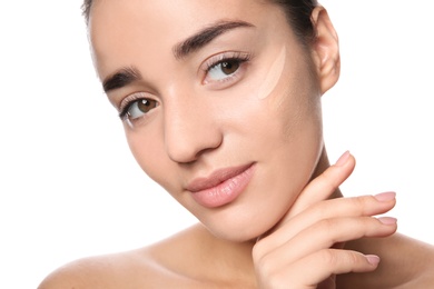 Photo of Young woman with different shades of skin foundation on her face against white background
