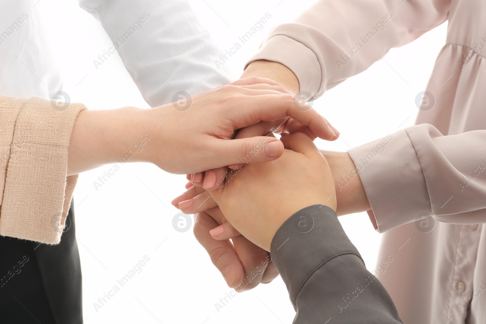 Photo of Group of people holding their hands together on white background, closeup