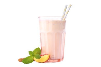 Photo of Tasty milk shake in glass with peach and almond on white background