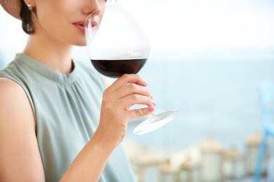 Photo of Young woman with glass of red wine outdoors