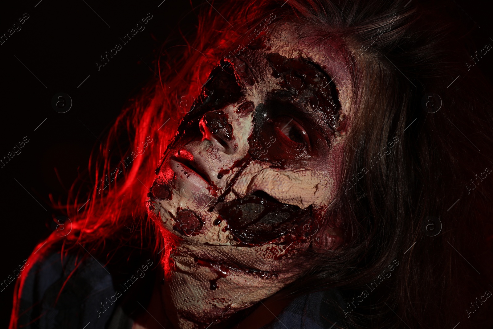 Photo of Scary zombie on dark background, closeup. Halloween monster