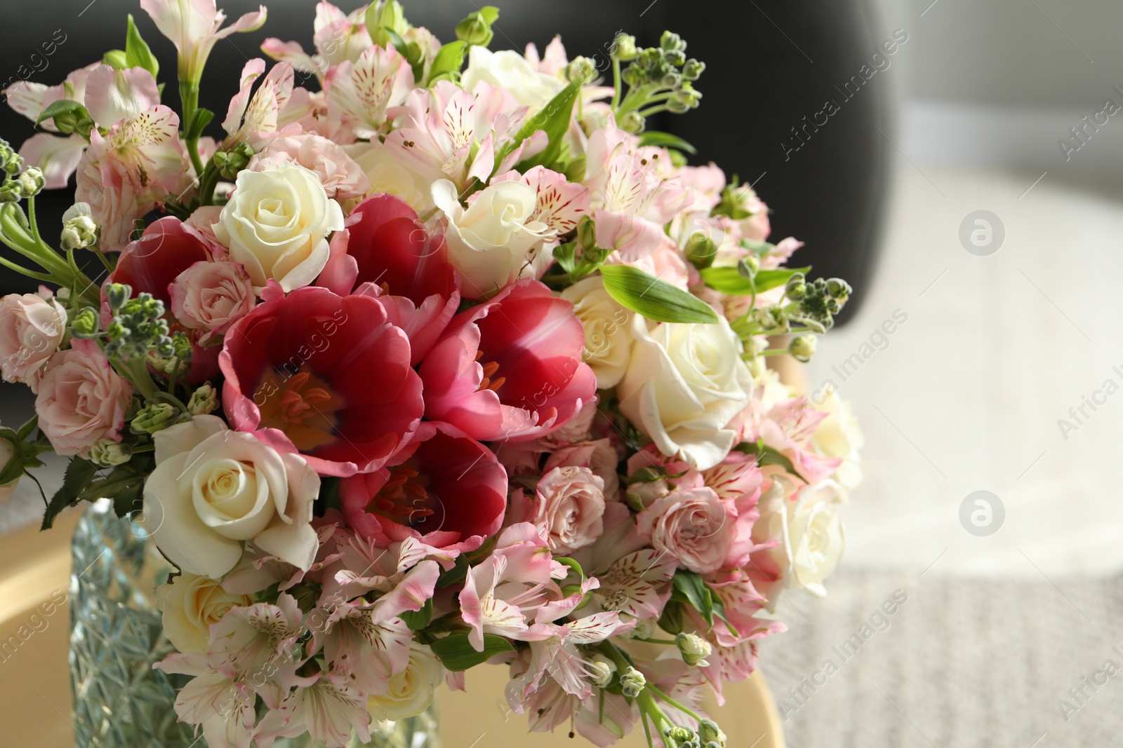 Photo of Beautiful bouquet of fresh flowers on table in room, closeup