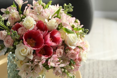 Beautiful bouquet of fresh flowers on table in room, closeup