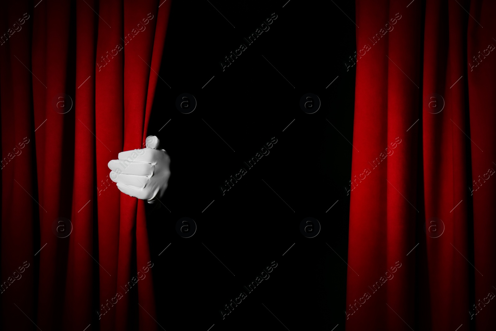 Photo of Person opening red front curtains on black background, closeup. Space for text