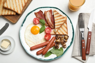 Photo of Tasty breakfast with fried egg served on light table, flat lay