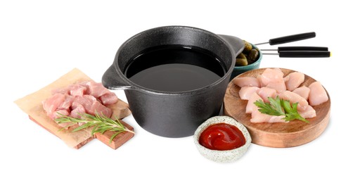 Fondue pot with oil, forks, raw meat pieces and other products isolated on white