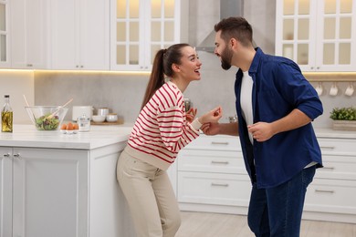 Photo of Happy lovely couple dancing together in kitchen