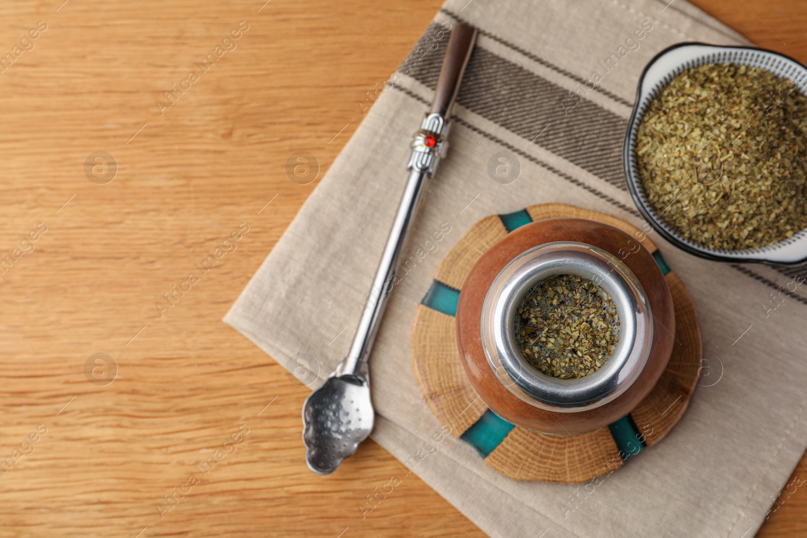 Photo of Calabash with mate tea and bombilla on wooden table, flat lay. Space for text