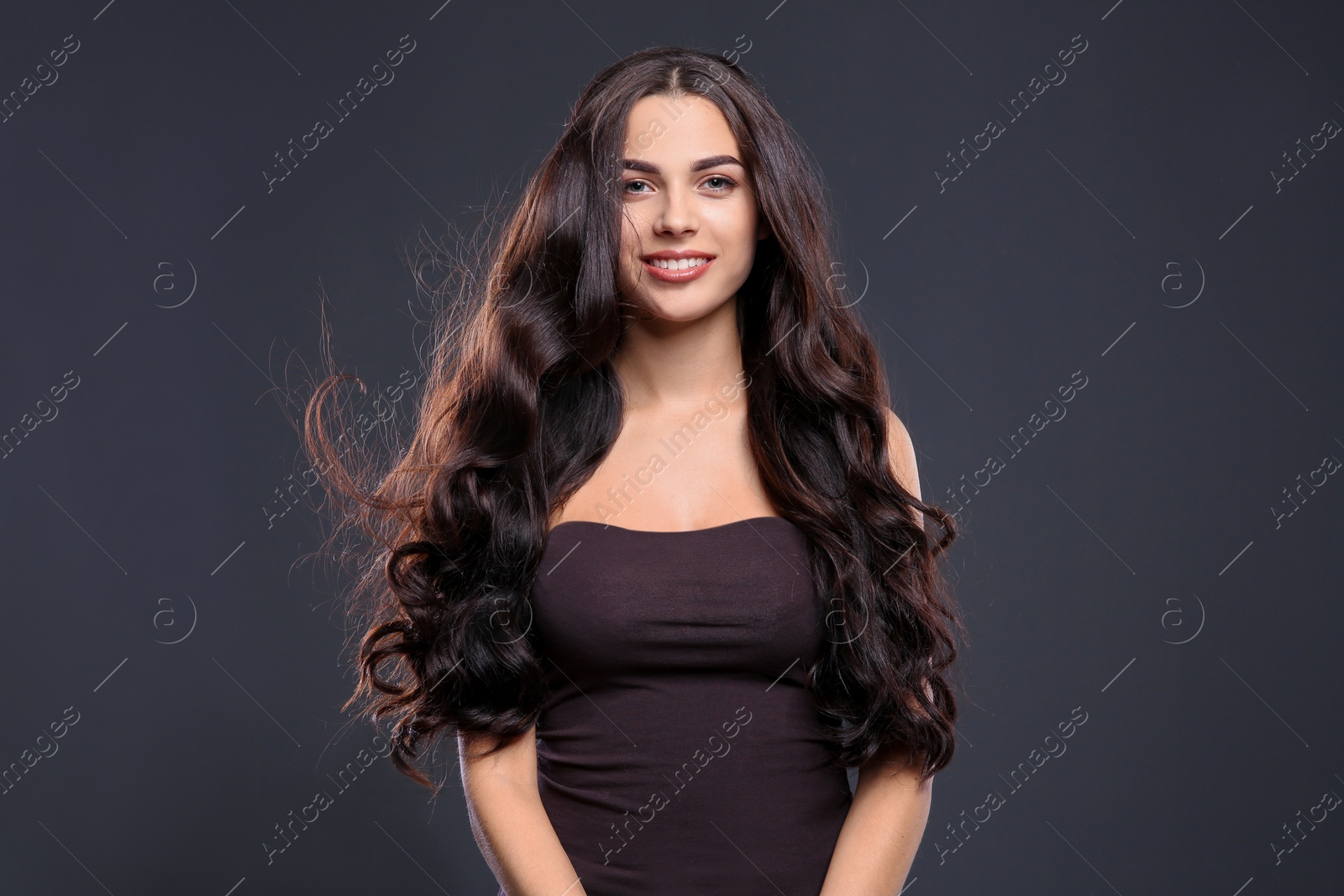 Photo of Portrait of beautiful model with gorgeous curly hair on black background