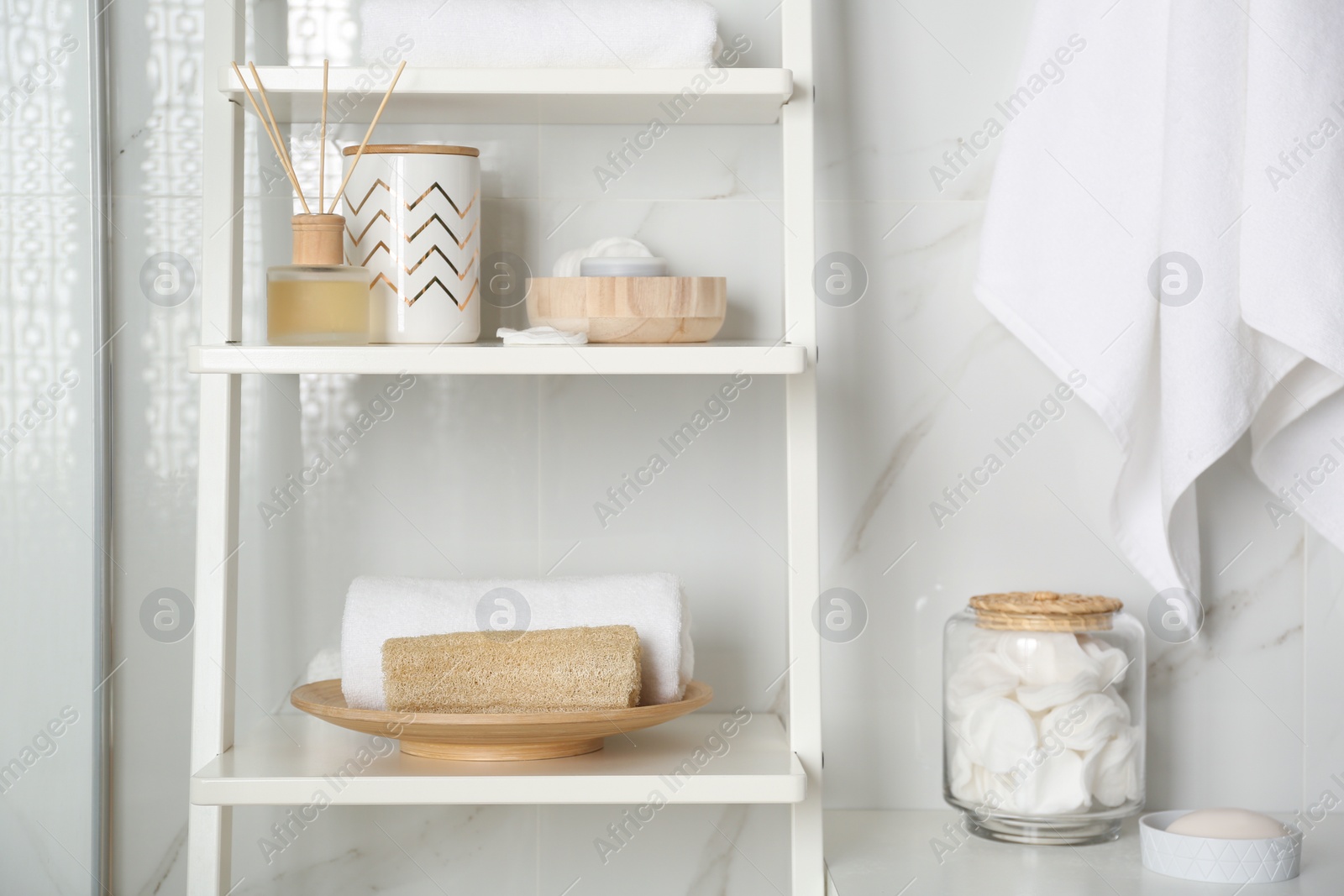 Photo of Shelving unit with different items in bathroom interior