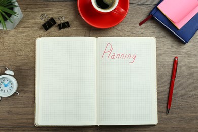 Notebook with word Planning, coffee, alarm clock and stationery on wooden table, flat lay