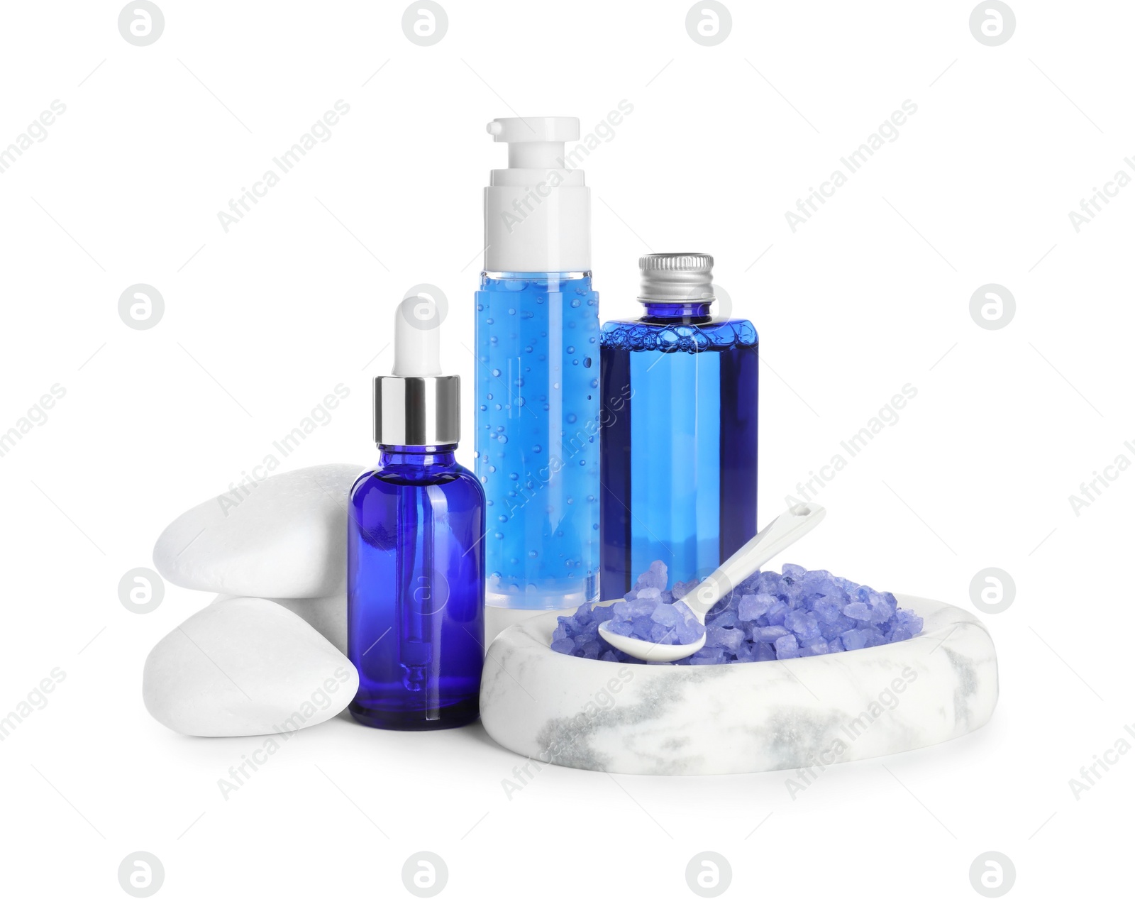 Photo of Spa composition. Bottles of cosmetic products, stones and sea salt isolated on white