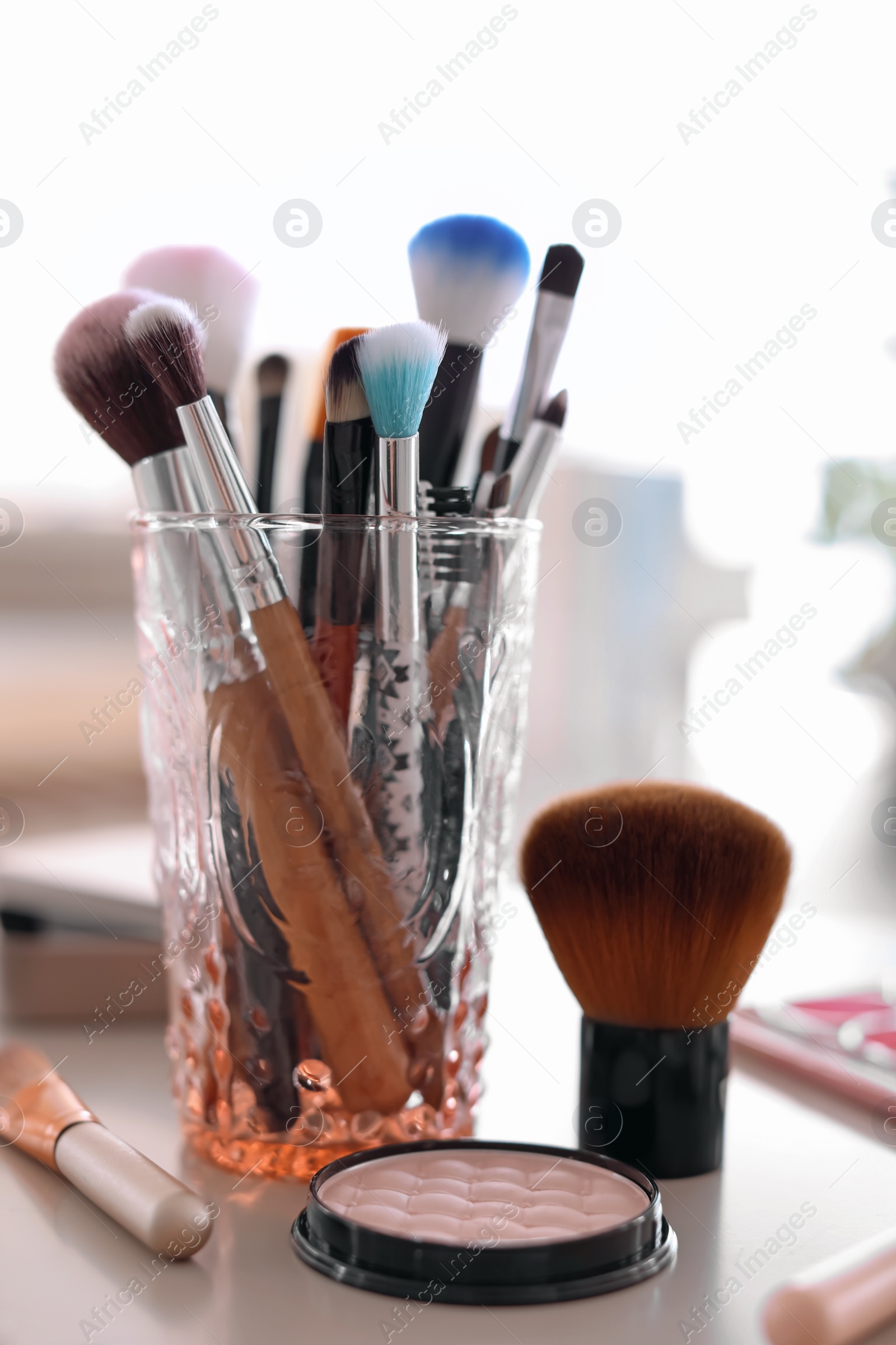 Photo of Holder with makeup brushes on table