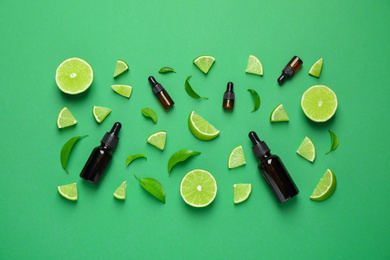 Photo of Flat lay composition with lime essential oil on green background