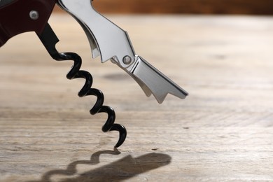 One corkscrew (sommelier knife) on wooden table, closeup