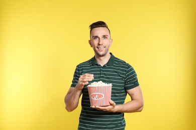 Photo of Man with popcorn during cinema show on color background