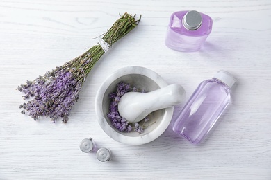 Photo of Flat lay composition with lavender flowers and natural cosmetic products on wooden background